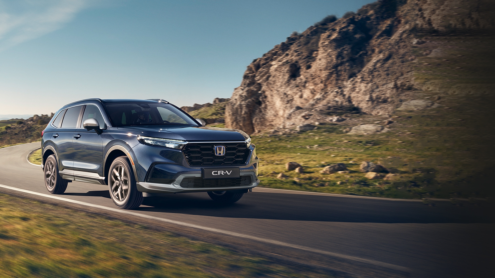 Trojštvrťový pohľad spredu na vozidlo Honda CR-V Hybrid pri jazde v horách.