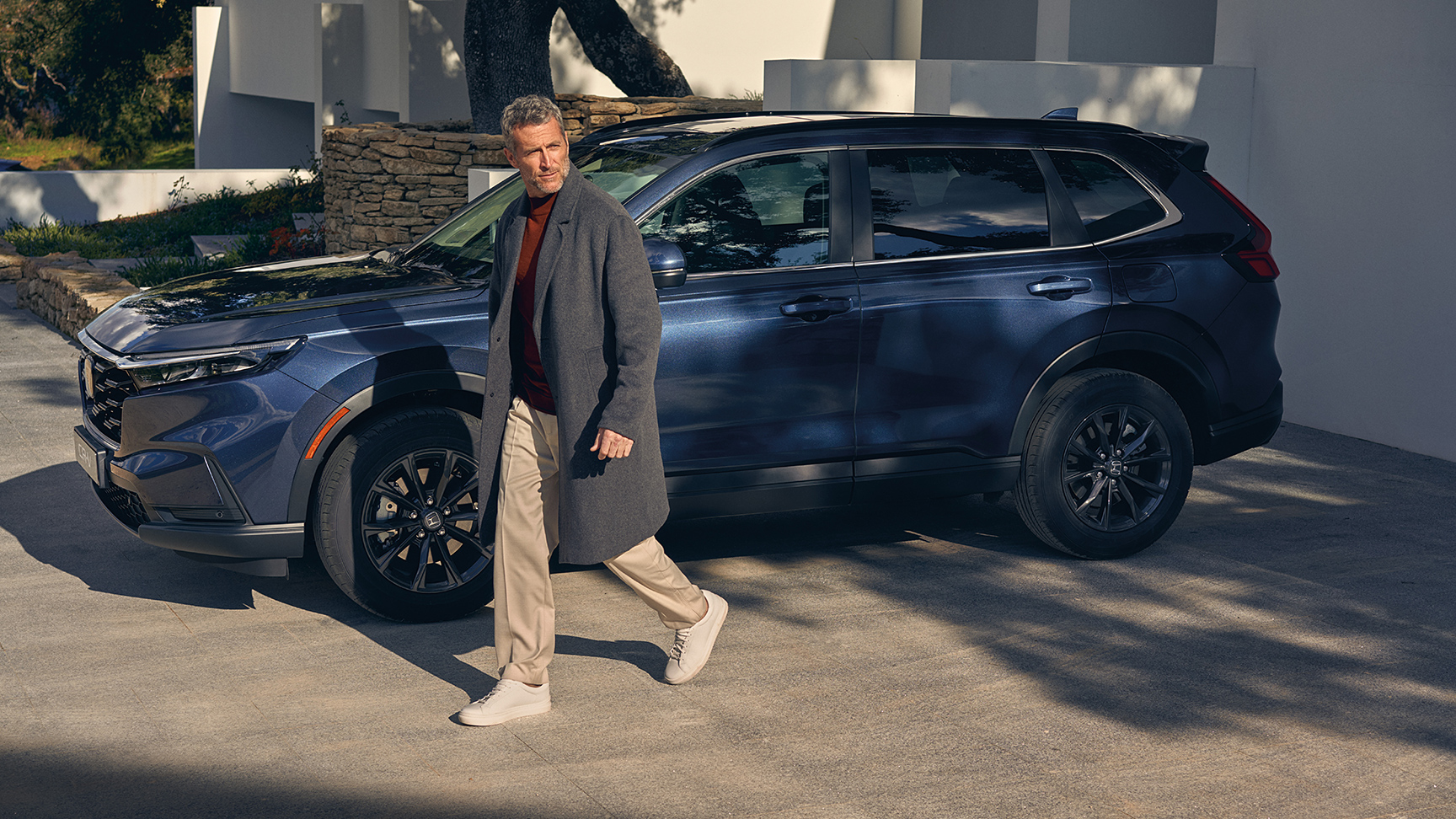 Pohľad zboku na model Honda CR-V Hybrid s figurantom.