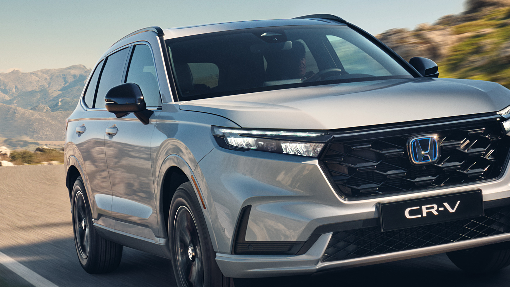 Trojštvrťový pohľad spredu na model Honda CR-V Hybrid v horách.