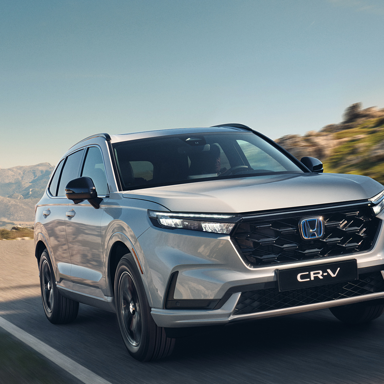 Trojštvrťový pohľad spredu na model Honda CR-V Hybrid v horách.