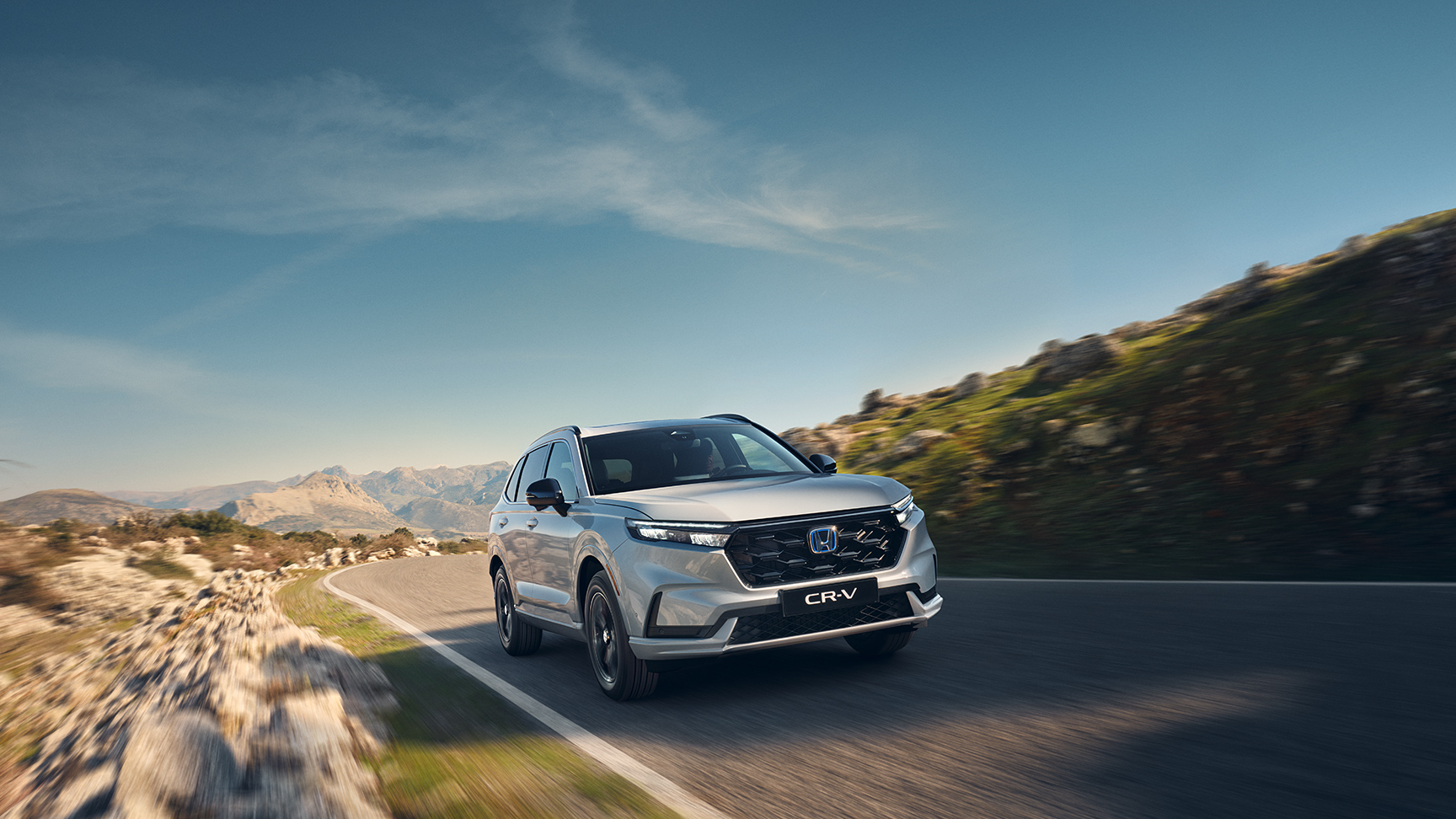 Trojštvrťový pohľad spredu na model Honda CR-V Hybrid v horách.
