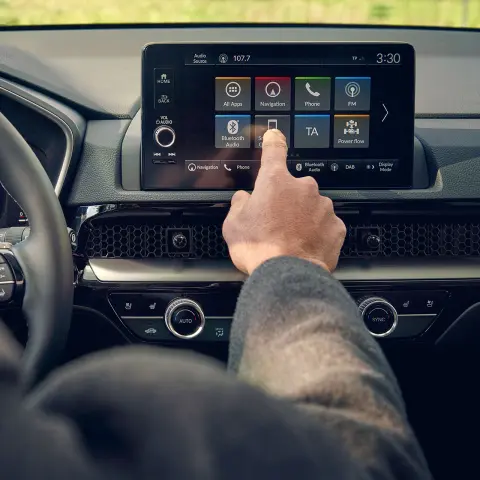 Záber na vodiča z interiéru pri používaní head-up displeja v modeli CR-V Hybrid SUV na parkovisku.