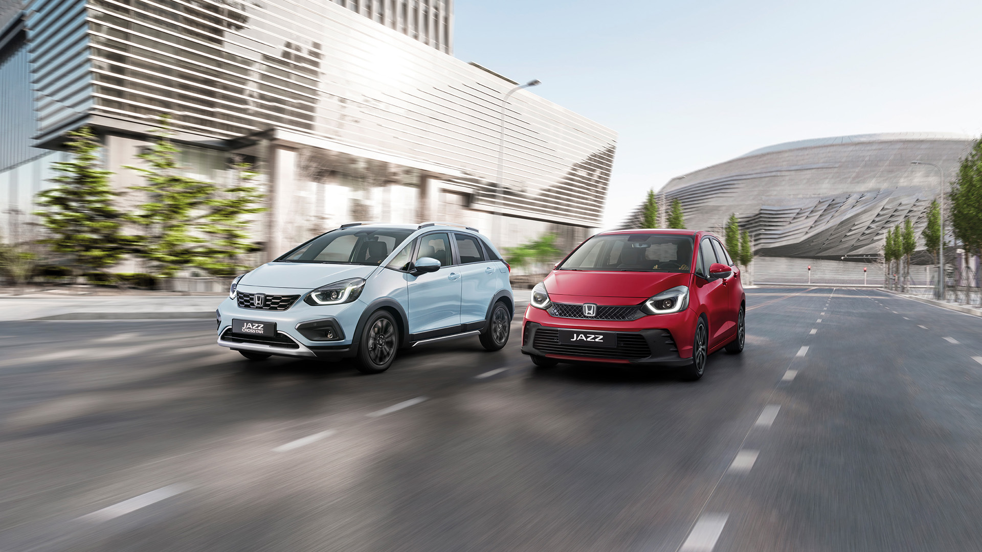 Honda Jazz Hybrid a Honda Jazz Crosstar jazdia vedľa seba v meste.