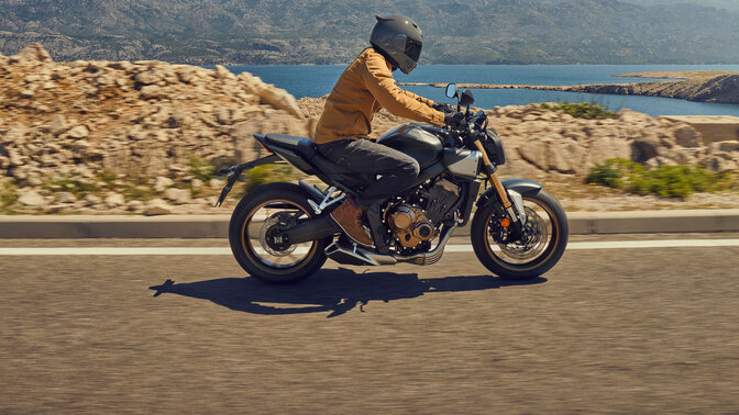 Trojštvrťový pohľad spredu na model Honda CB650R pri jazde na parkovisku