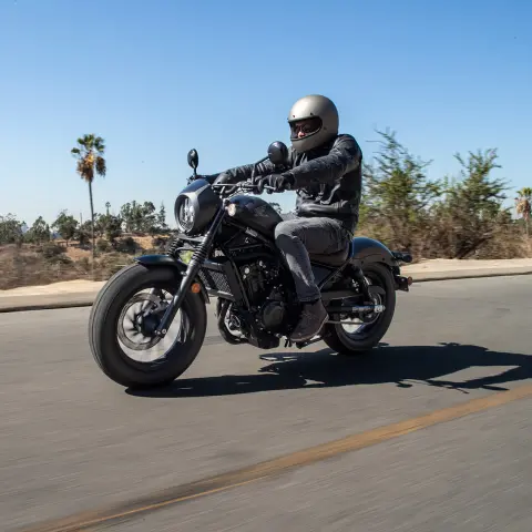 Honda CMX500 Rebel s jazdcom pri jazde po ceste. 